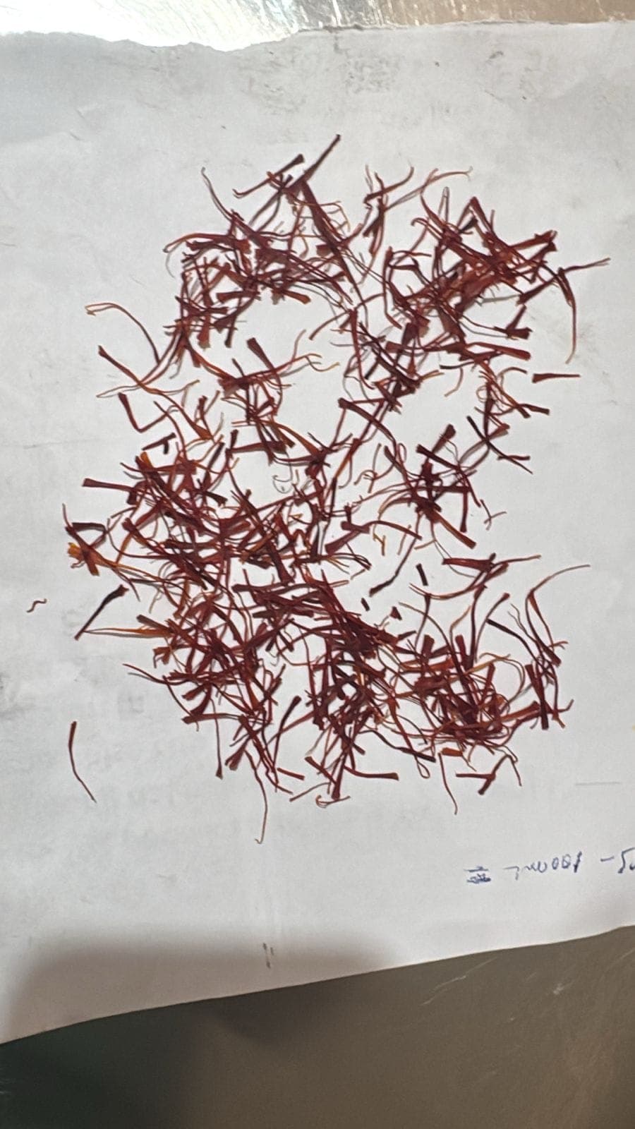 Dried Kashmiri saffron threads laid out for grading — how real Mongra saffron looks before packing