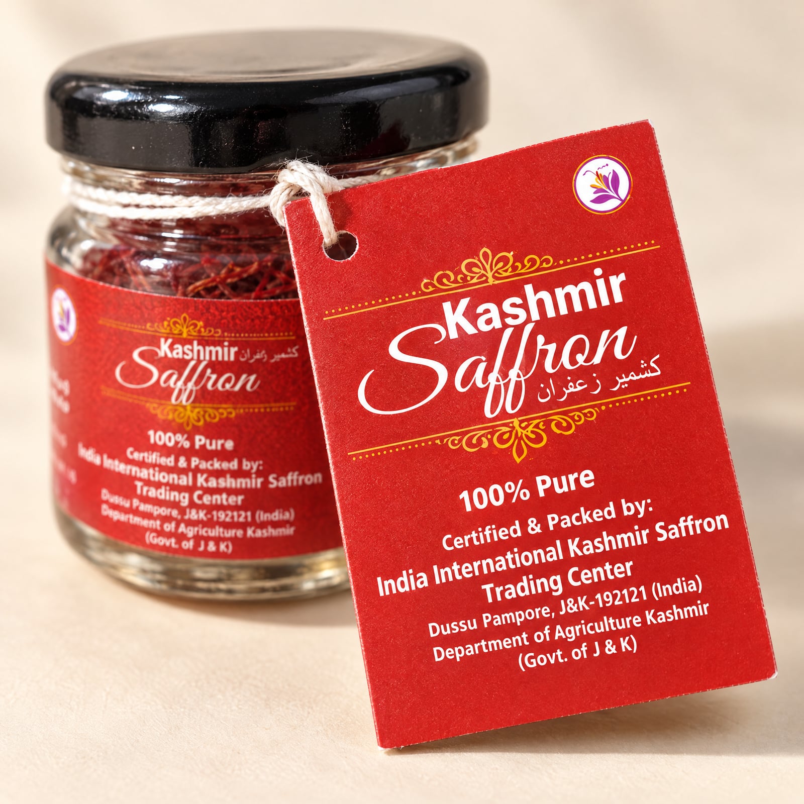 The red hang tag held in front of the jar, reading Kashmir Saffron, 100% Pure, Certified & Packed by India International Kashmir Saffron Trading Center